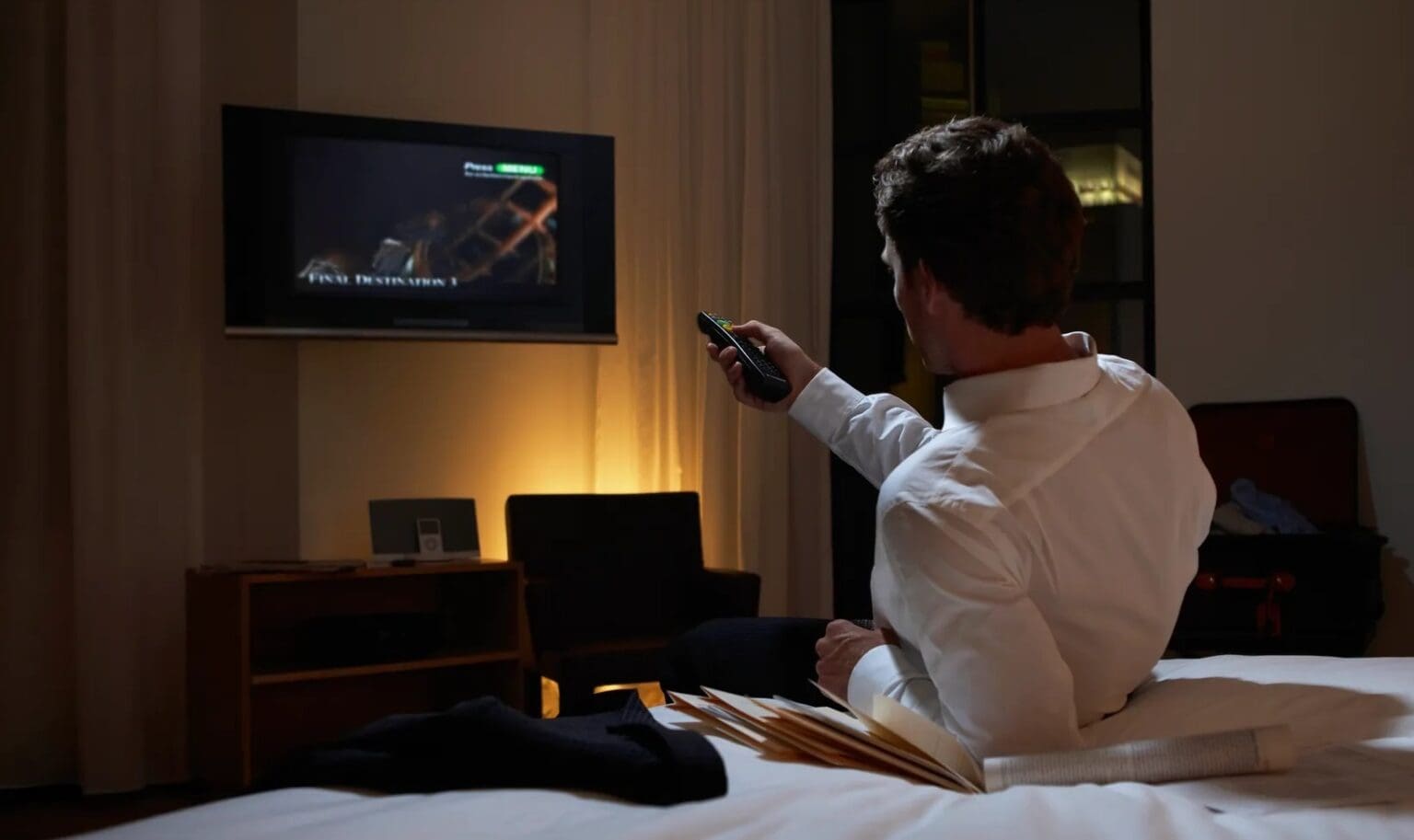 Picture of a man using a remote control in a hotel room